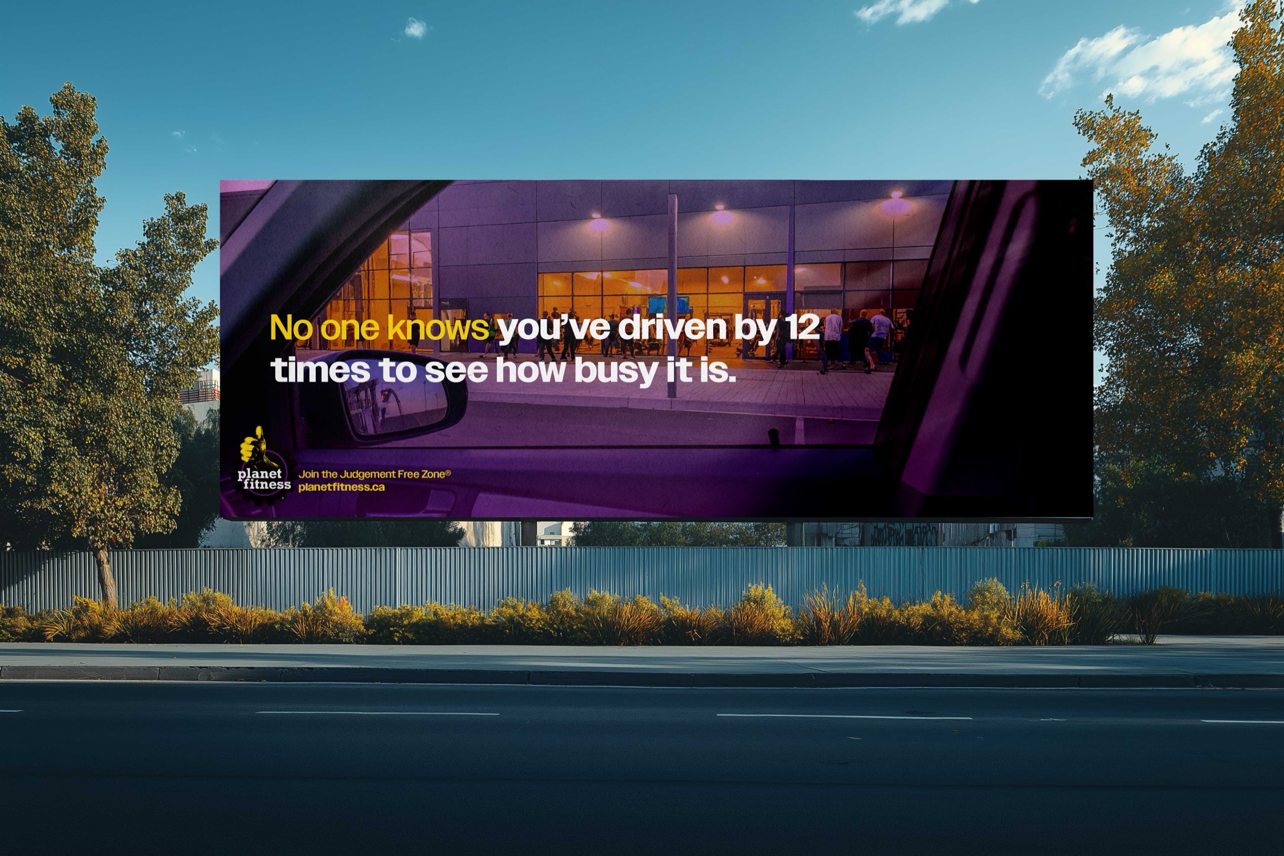 Roadside billboard: a gym seen from inside a parked car at night. No one knows you’ve driven by 12 times to see how busy it is. Join the Judgement Free Zone®.